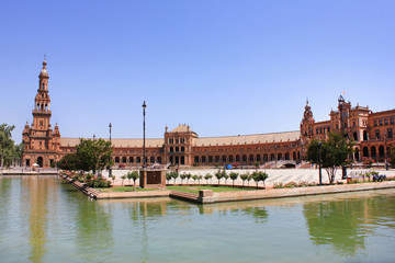 Obraz premium Plaza de Espana world famous Square in Seville, Spain. Renaissance Revival style in Spanish Architecture. Buildings complex with North Tower, water canal on green trees blue sky summer day background