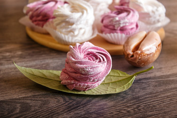 pink and white marshmallows (zephyr) on a round wooden board with  seashells