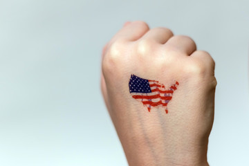 A human fist with images of the symbols of the flag and the territory of the United States.