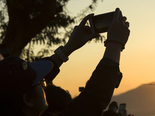 Person's hand taking picture with smartphone, Mount Phousi, Luang Prabang, Laos