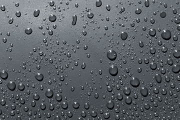Closeup of raindrops on gray surface, abstract background