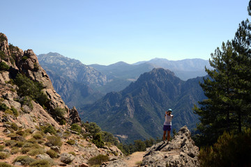 Fototapeta na wymiar Tourist resting and watching the mountains, Corsica