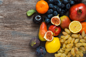 A collection of fruits on a wooden surface, top view.