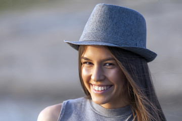 Portrait of happy smiling young girl with a hat