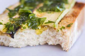 Close up of a bitten bruschetta with zucchini.