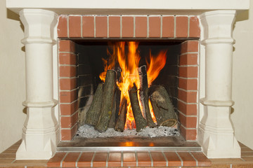 White fireplace with a burning fire