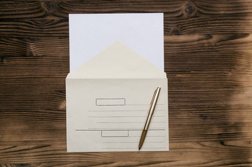 Letter on the wooden table. Paper envelope with copy space and pen. Contact us. Feedback.