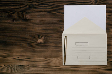 Letter on the wooden table. Paper envelope with copy space and pen. Contact us. Feedback.