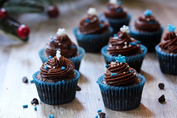 Mini Frosted Chocolate cupcakes on Christmas Holiday background
