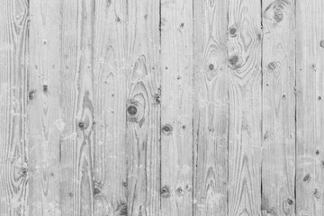 Wooden beach boardwalk with sand, viewed from above, background in black and white.