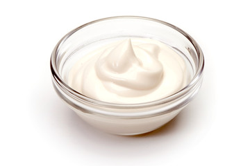 Bowl of sour cream on white background