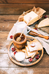 A composition of Russian traditional homemade pancakes served with honey and berries