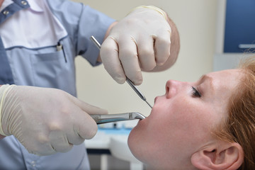 Tooth Extraction procedure with forceps, closeup portrait of woman patient during operation in dentist clinic