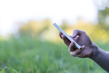Smartphone in Männerhand, Seitenansicht, draußen, Textfreiraum