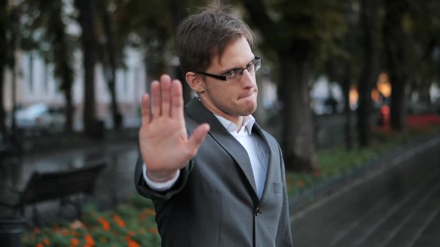No, Never, Businessman Disliking and Rejecting Gesture by Stop Sign. Slow motion. Portrait of young successful confident businessman in the city. Man in a business suit.