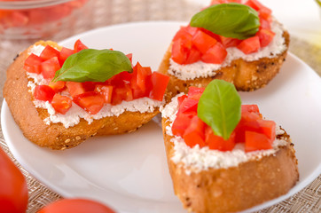 delicious bruschetta with tomatoes on plate on table close-up