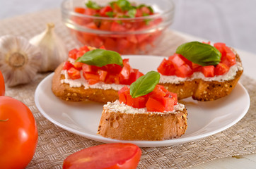 delicious bruschetta with tomatoes on plate on table close-up