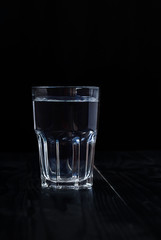 Just a glass of water on a black background.