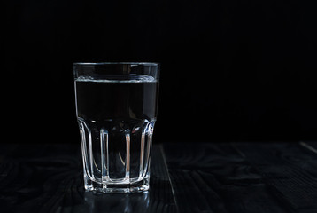 Just a glass of water on a black background.