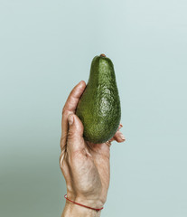 Style minimalism. Ripe avocado in a woman's hand.