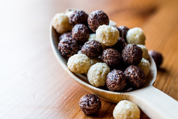 Chocolate Cereal balls in wooden spoon.