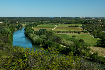 French winery landscape with Vidourle river in the foreground and Aubais village on the background during the summer, Languedic region