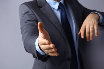 Man wearing a suit offering to shake hands