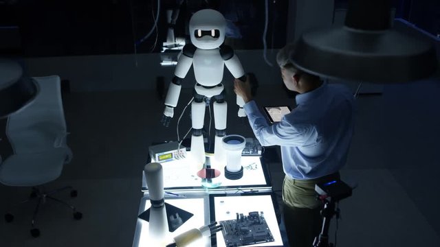  Electronics engineer working on design of robot in dark lab