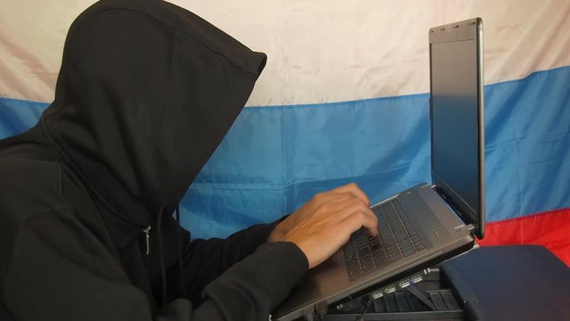 Man with laptop on the background of the Russian flag. A hacker against the background of the flag of Russia.