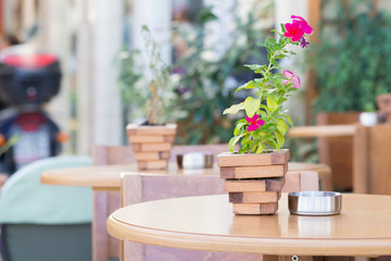 purple petunia in a small wooden pot on a coffee table