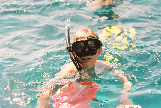 Teenage Boy In The Ocean Wearing A Mask And Snorkel