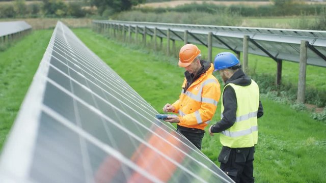  Technicians checking the panels at solar energy installation