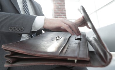 businessman's hand with suitecase in a modern office
