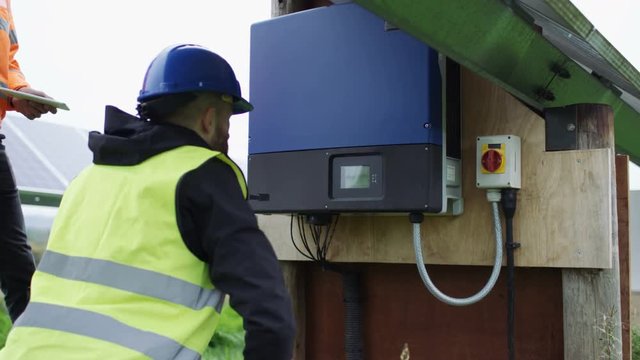  Technicians checking the electricity box at solar energy installation