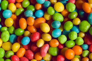 Tasty candy decoration background. Heap of colors candies for kids with small green, yellow, blue sweets