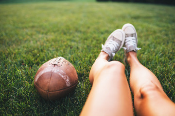 Woman holding football while sitting in the backyard