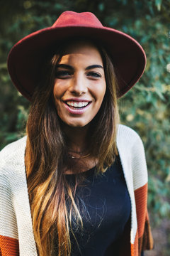Portrait of a smiling hipster woman in the woods.