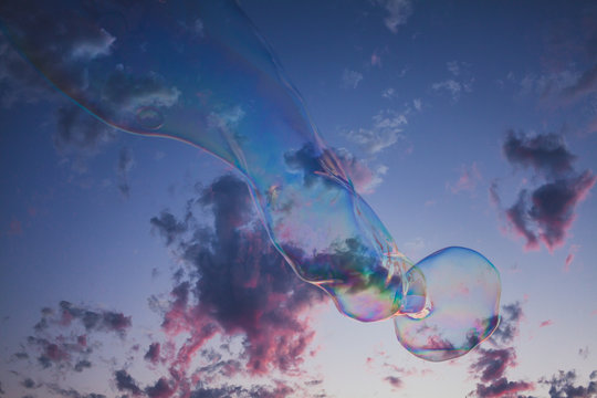 Large bubble floating along the beach at sunset.