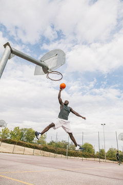 Young Black Man Playing in a Street Basketball Court