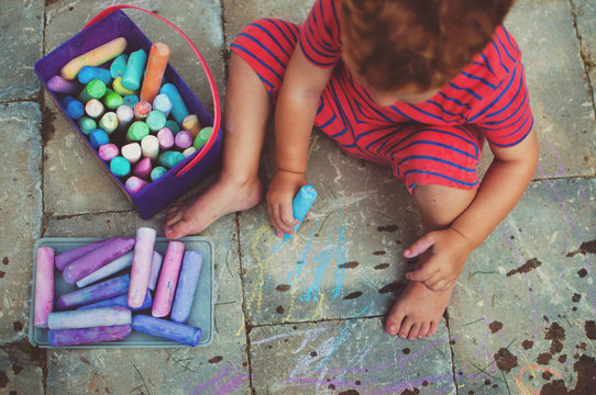 A young boy drawing with chalk.