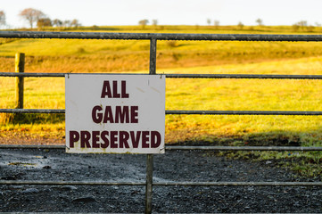 "All Game Preserved" sign on a five bar field gate, preventing hunting in a field