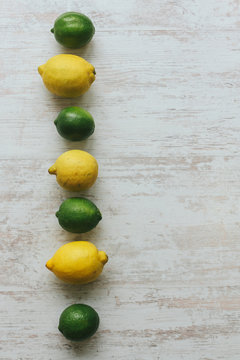 lemons and limes on white wooden background