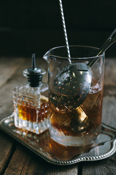 classic manhattan cocktail ingredients in a mixing tumbler on a salver