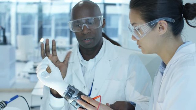  Scientific research engineers collaborating on project to build robotic hand