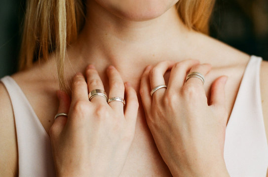 Close up shot of woman's hands on her collarbone