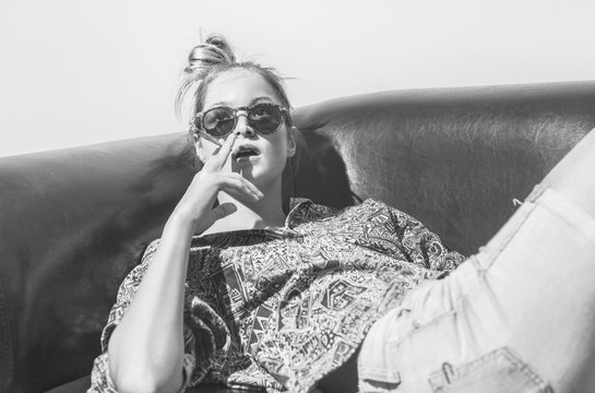 Black and white portrait of hip sensual female smoking weed.