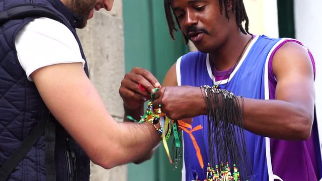 Street Vendor Welcoming Tourist Giving Some Brazilian Ribbons (Fita do Bonfim) on in Salvador, Bahia, Brazil