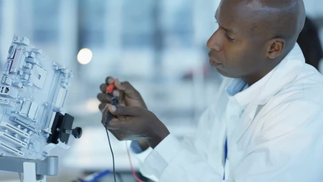 Engineer working in electronics factory building and testing electronic devices