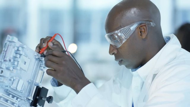  Engineer working in electronics factory building & testing electronic devices