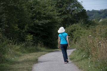 Fototapeta premium a blonde woman walks a countryside path